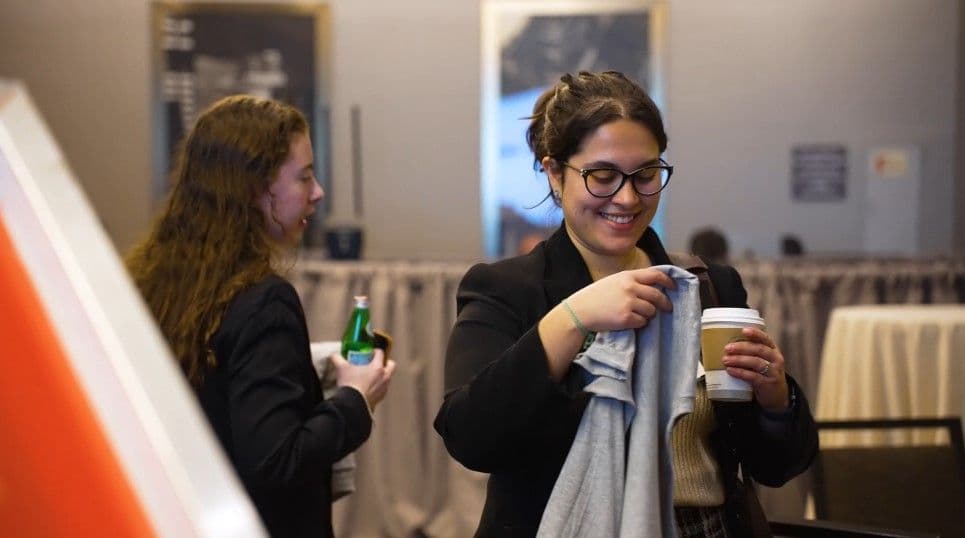 Corporate event guest holding a freshly printed shirt from the live printing station