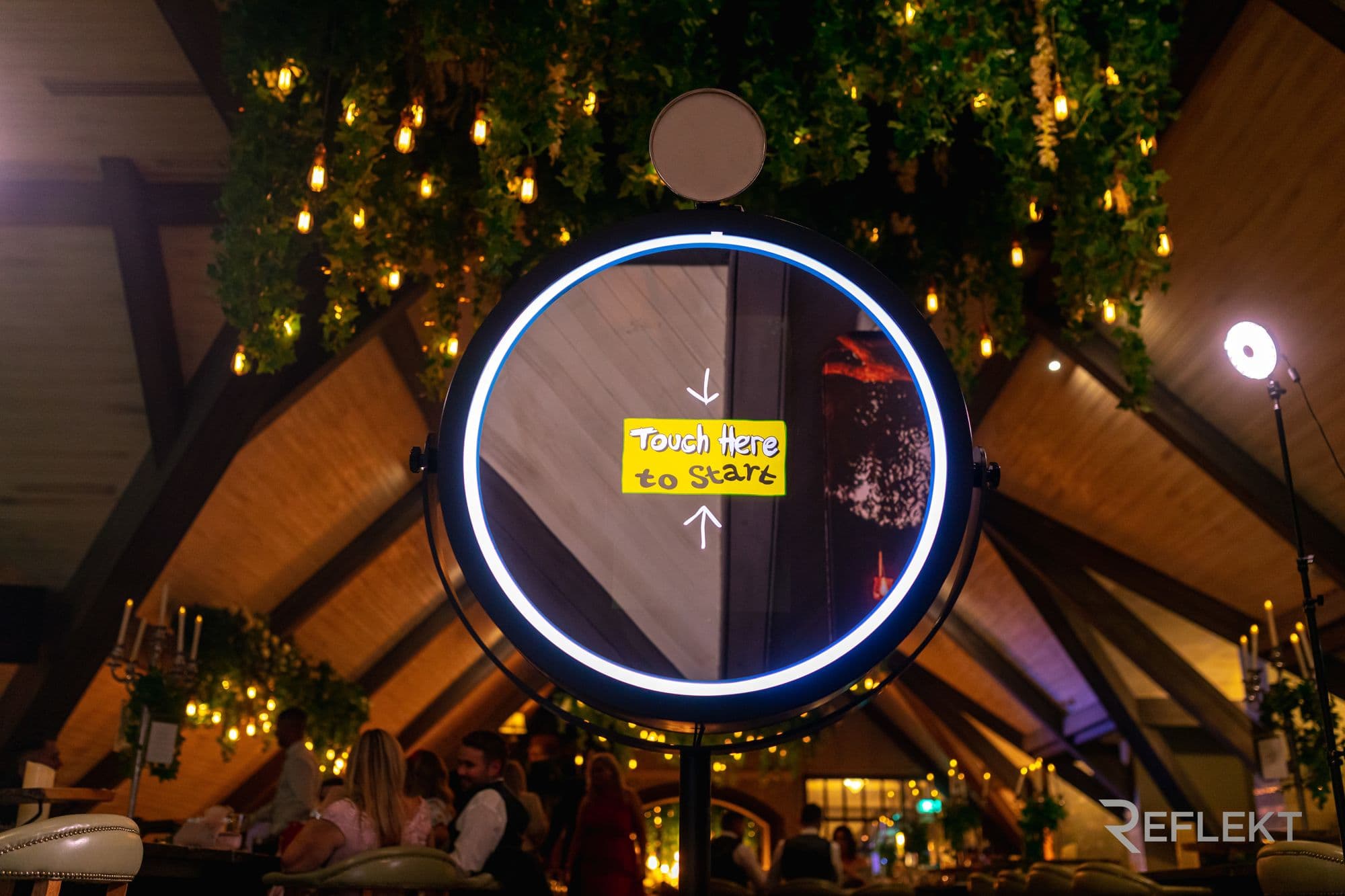 Round beauty mirror photo booth set up in a restaurant venue