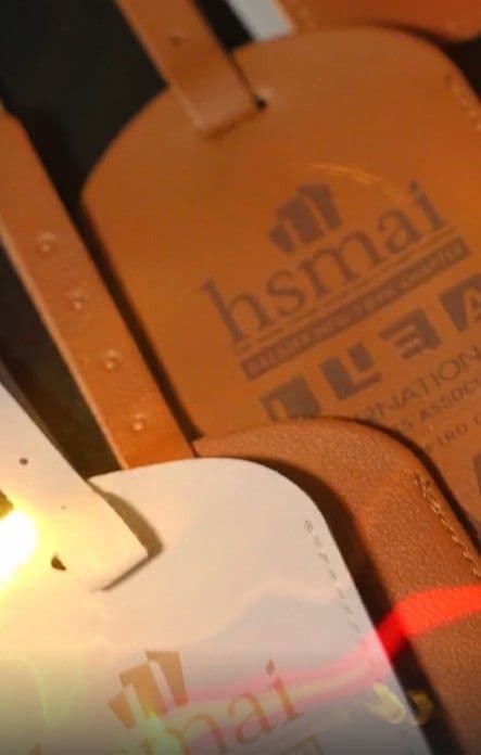 Leather luggage tag laser engraved with an association logo on site