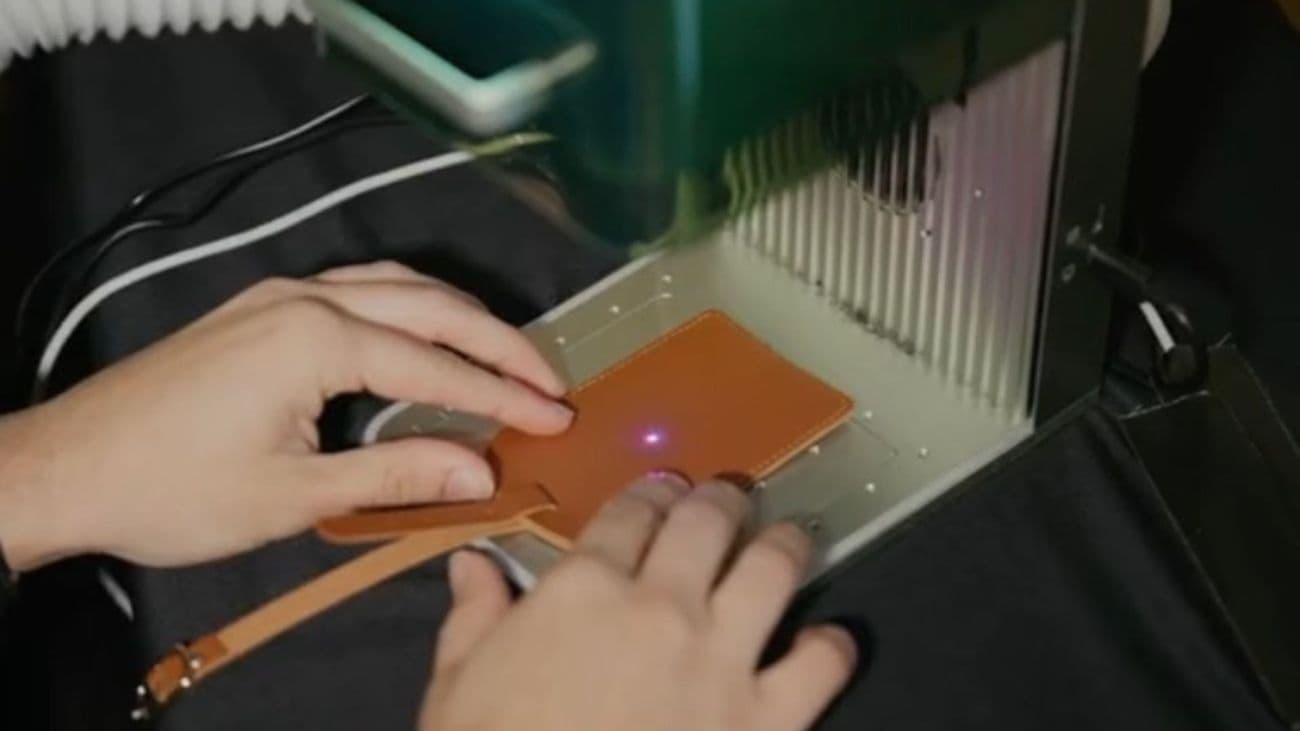 Leather patch being positioned in a laser engraver at a live event