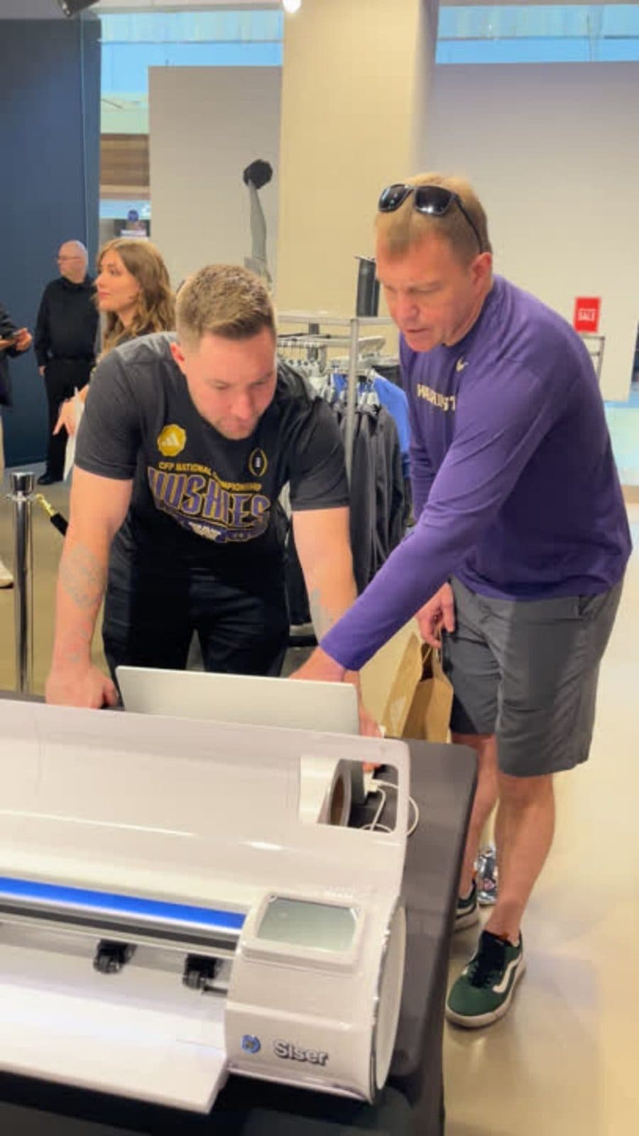 Live personalization station printing custom fan gear inside a university team store