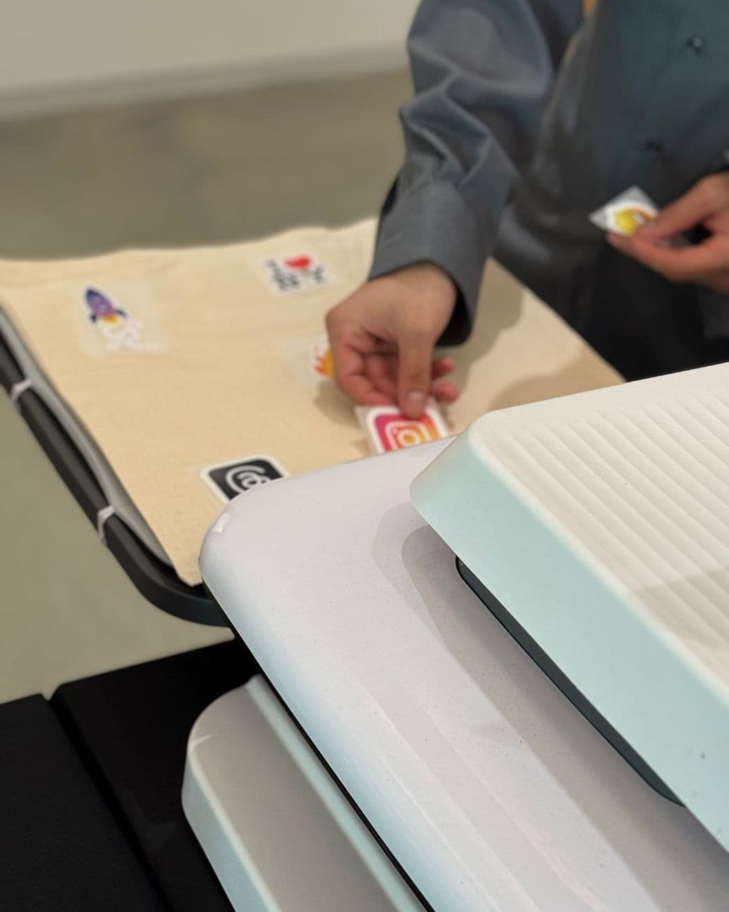 Guest placing a design on a tote bag before it is heat pressed on site