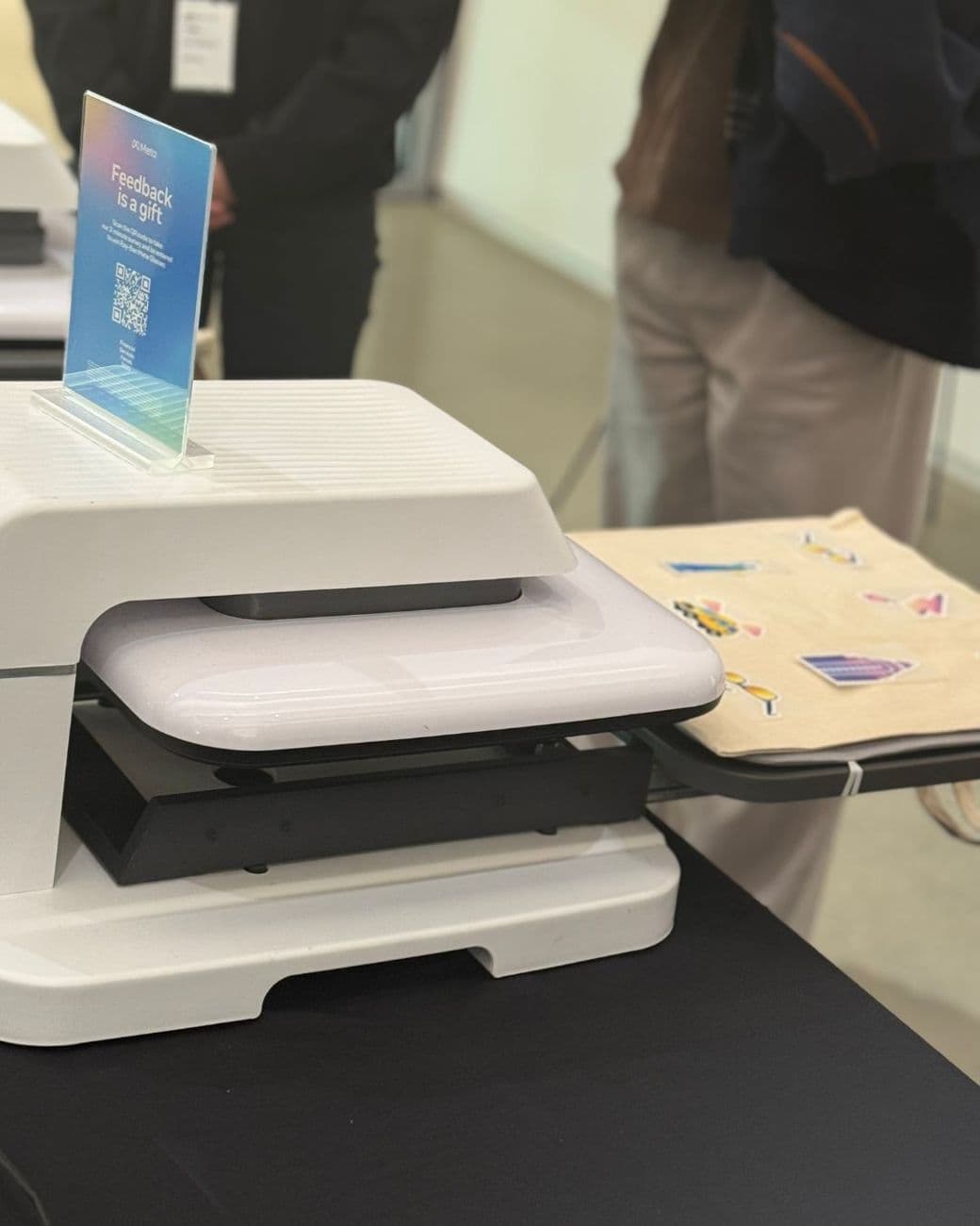 Heat press applying a guest's chosen designs to a canvas tote at a brand event