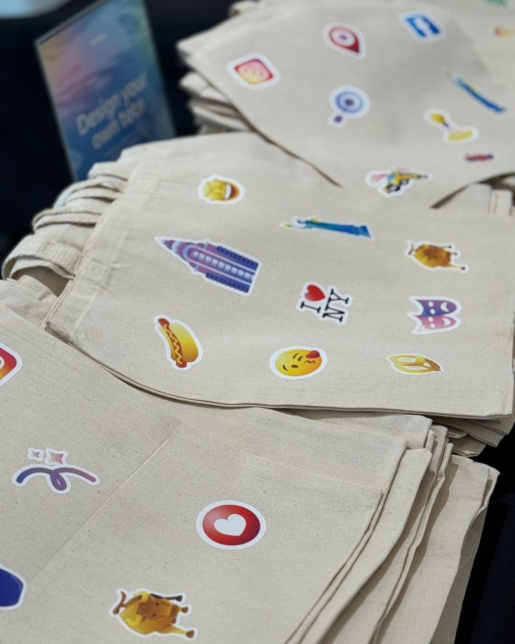 Canvas tote bags customized with press-on patches at a design-your-own tote bar