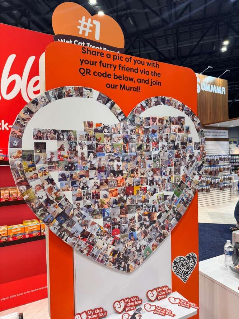 Heart-shaped photo mosaic wall built from guest photos at a trade show booth