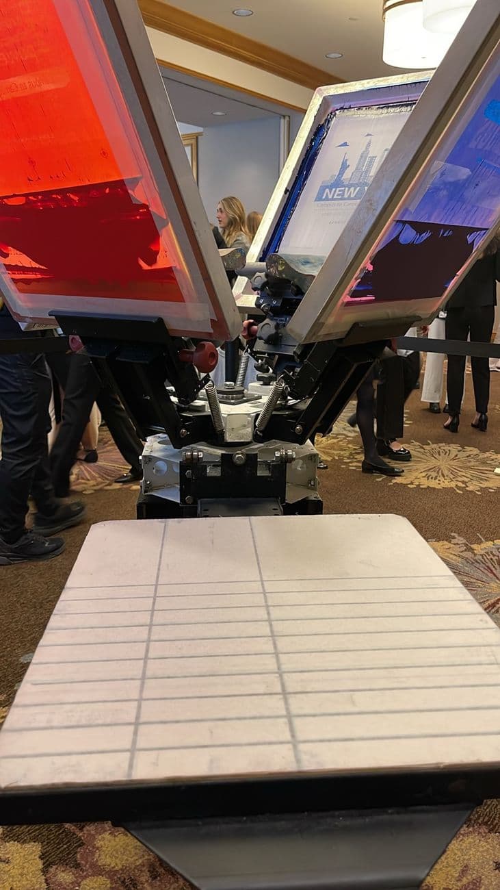 On-site screen printing press set up on a hotel ballroom floor for a live event